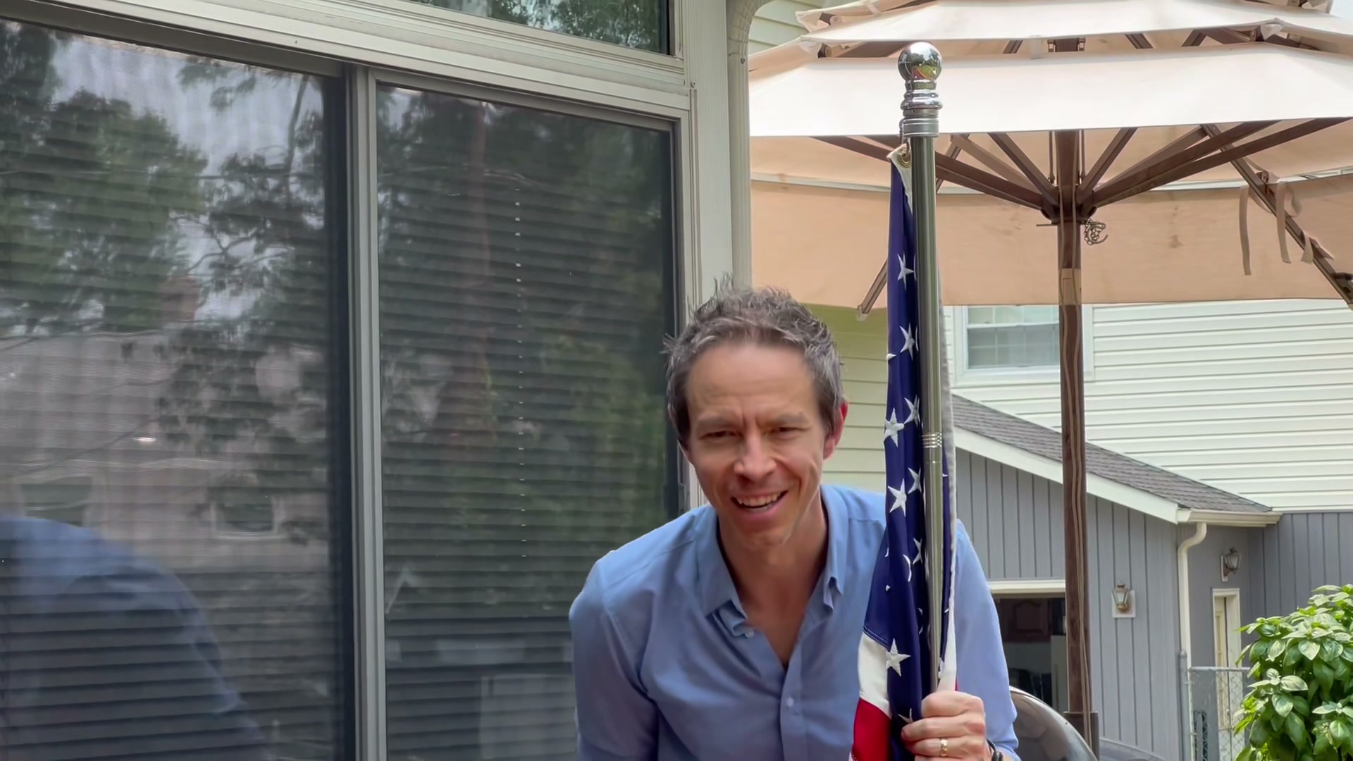 Jeff Appelhans smiling beside the Appelhans flag.